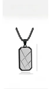 Macro view of men's geometric titanium steel tag necklace with brushed metal textures