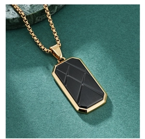 Detailed macro view of the black geometric pendant with a gold border on a green stone