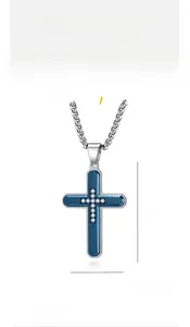 Detail of silver and blue titanium steel cross pendant with white zircon inlays
