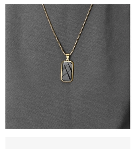 Macro shot of gold-framed black rectangular pendant with geometric knife marks