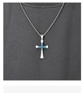 Détail macro du pendentif croix en argent avec incrustation bleu clair et zircones