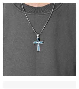 Detail of men's titanium steel blue cross pendant with sparkling stones and metal chain