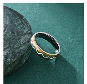 Macro view of bicolor titanium steel ring with jagged edges and a single diamond inlay