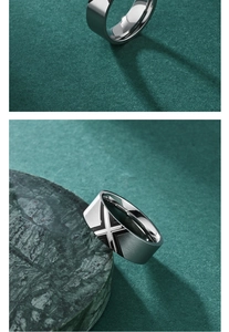 Detail of brushed titanium steel ring featuring a black X pattern on green marble