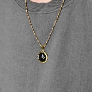 Collana da uomo con ciondolo bussola dorata, stella in smalto nero e catena box su modello