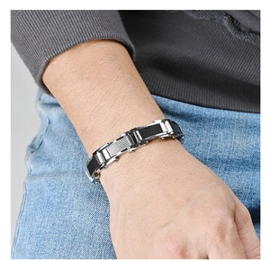 Détail d'un bracelet pour homme en acier inoxydable et caoutchouc de style industriel