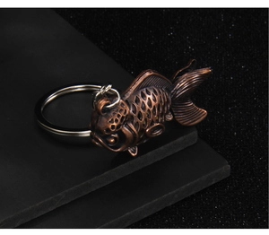 Macro detail of vintage bronze carp pendant with intricate scale carvings on black texture