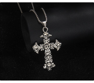 Détail d'un pendentif croix tête de mort gothique sur chaîne à billes, finition vieillie