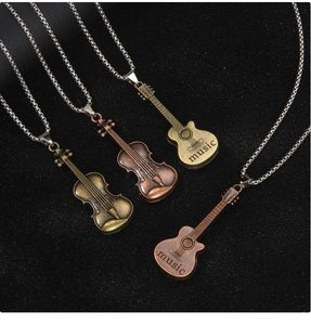 Detail of vintage bronze music necklace with violin and guitar pendants on black background