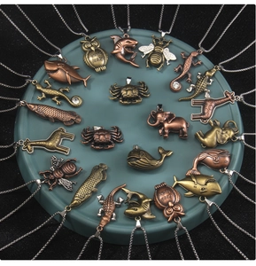 Detailed close-up of retro animal alloy pendants with antique finish on a display tray