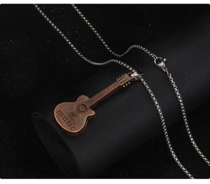 Macro shot of vintage bronze guitar pendant with music engraving on silver box chain