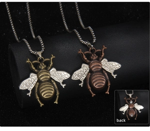 Detailed view of vintage bee pendants in bronze and copper tones with bead chains