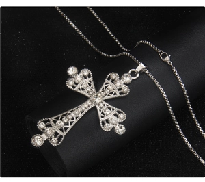 Close-up of cyber punk cross necklace with rhinestones on a leather pedestal