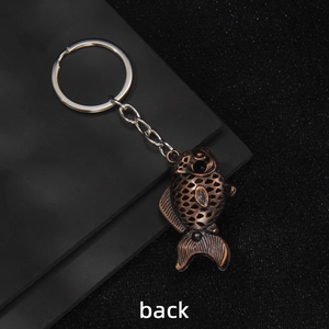 Vintage bronze carp keychain with hollow pattern design shown from the back view