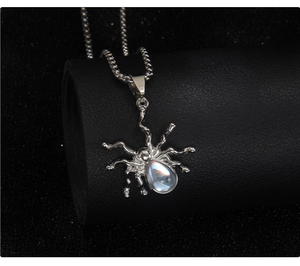 Detail of silver spider pendant with teardrop opal stone on a gothic pearl chain