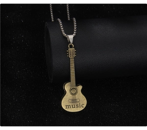 Detailed view of vintage bronze guitar pendant with music engraving on a silver bead chain
