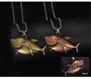 Detailed close-up of shark pendant showing vintage gold and bronze finish with back view