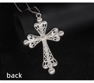 Detailed macro view of the filigree pattern on the back of the silver cross pendant
