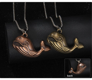 Macro detail of vintage bronze whale pendant showing embossed texture and back view