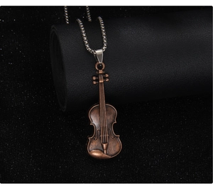 Macro view of vintage bronze violin pendant with detailed strings on silver metal chain