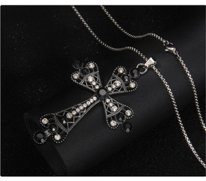 Detailed macro of a gothic cross pendant with inlaid rhinestones on a leather stand