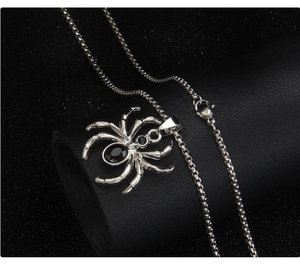 Macro shot of punk spider pendant necklace featuring black gemstones and box chain