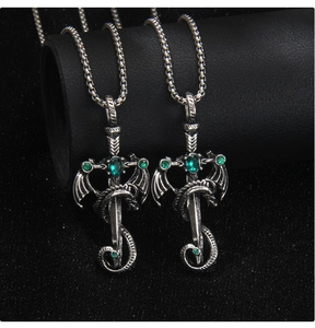 Detail of vintage gothic dragon sword pendant with green gems on black leather