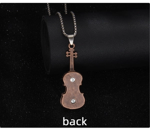 Detail view of the back of a vintage violin pendant necklace with silver chain on leather