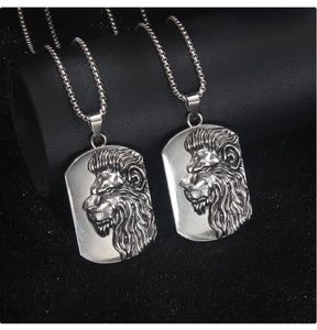 Gros plan détaillé de deux pendentifs tête de lion en relief argenté avec chaînes à billes