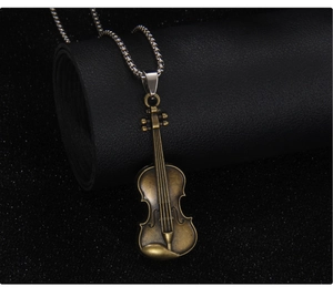 Detailed close-up of a vintage bronze violin pendant with intricate musical details
