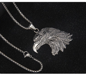 Détail macro du pendentif tête d'aigle vintage en acier inoxydable avec chaîne box