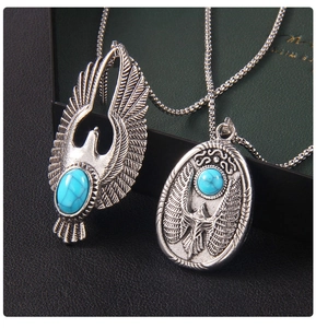 Détail macro du pendentif aigle argenté vintage avec incrustation de turquoise