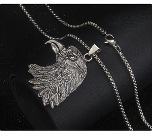 Gros plan détaillé du pendentif tête d'aigle vintage sur une chaîne en acier inoxydable