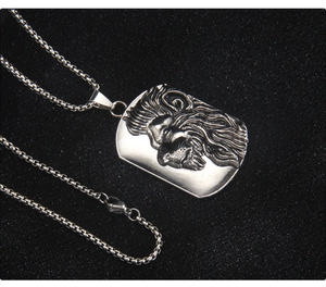 Détail du relief tête de lion sur un pendentif rectangulaire en acier inoxydable vintage