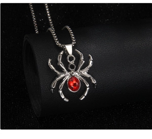 Detail of spider pendant with red crystal and silver beaded chain on leather