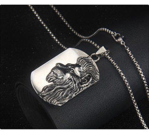 Gros plan d'un pendentif lion en acier inoxydable argenté sur une chaîne maille box