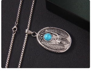 Détail du pendentif aigle vintage avec ailes gravées et une pierre de turquoise naturelle