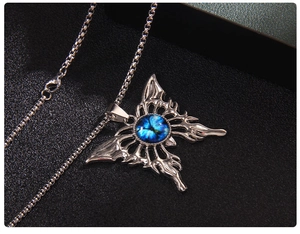 Dettaglio collana gotica a farfalla con occhio blu centrale e catena a maglia quadra