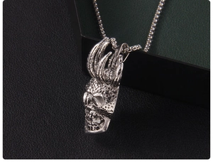 Vue détaillée du pendentif crâne gothique avec finition argentée et accents de griffes