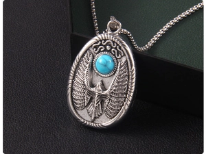 Détail macro du pendentif aigle vintage avec pierre turquoise bleue et finition argent vieilli