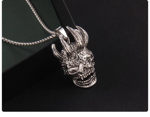 Gros plan détaillé du pendentif crâne argenté vintage avec cornes et textures d'écailles