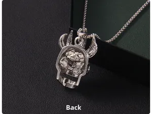 Vue macro du dos évidé du pendentif tête de mort démon punk en argenté sur fond noir
