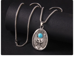 Détail du pendentif aigle vintage avec pierre turquoise sur une chaîne en métal argenté