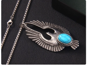 Détail du pendentif aigle vintage avec pierre turquoise bleue sur chaîne en acier