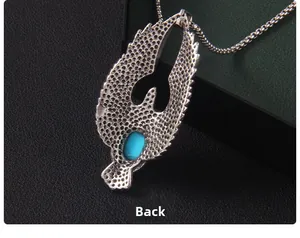 Détail de l'arrière du pendentif aigle avec texture métallique et incrustation de turquoise