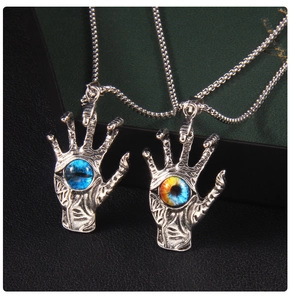Detailed macro view of two vintage evil eye claw pendants with antique silver finish