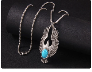 Détail du collier aigle vintage avec ailes argentées et pierre turquoise bleue éclatante