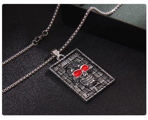 Macro detail of gothic skull pendant with red eyes and woven texture on square dog tag
