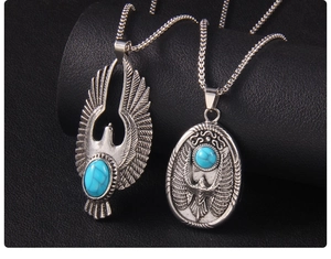 Détails de pendentifs aigle rétro avec pierres turquoise sur fond texturé noir