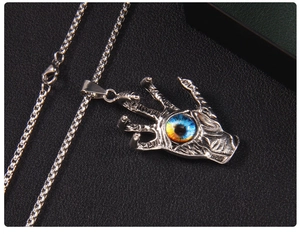Detailed close-up of a gothic evil eye hand pendant on a stainless steel box chain